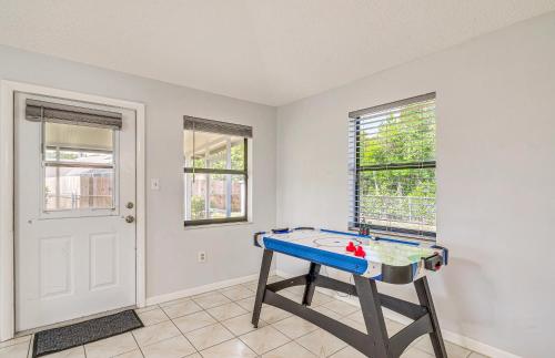 a ping pong table in a room with windows at 13 Mi to Hudson Beach Spring Hill Home with Lanai in Spring Hill