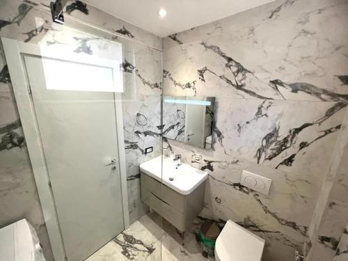 a bathroom with a toilet and a sink and a shower at Blue Luxury Apartment in Golem