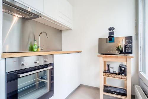 a kitchen with a sink and a stove at Aurora Suite à Champel avec terrasse in Geneva