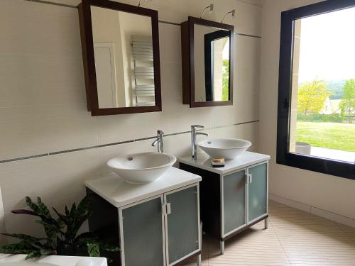 ein Badezimmer mit zwei Waschbecken und zwei Spiegeln in der Unterkunft Villa Serenity in Chambourcy