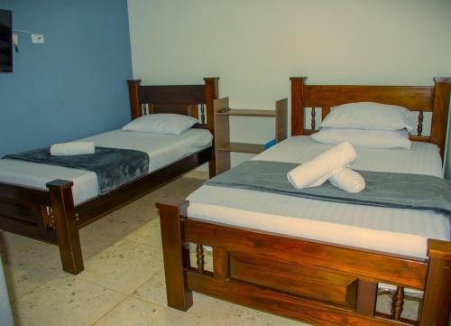 two beds sitting in a room with at Finca hotel el porvenir in Quimbaya