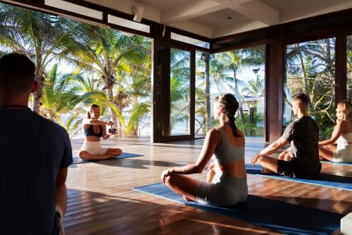 eine Gruppe von Menschen in einem Yoga-Kurs in der Unterkunft Lula Seaside Boutique Hotel in Tulum