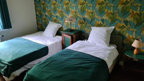 two beds sitting next to each other in a room at LA TANIÈRE in Gueures