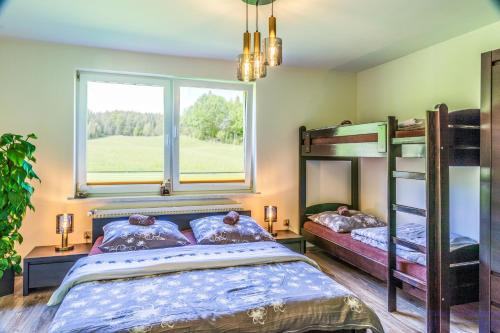 1 Schlafzimmer mit 2 Etagenbetten und einem Fenster in der Unterkunft Pokoje u Marioli in Wisła