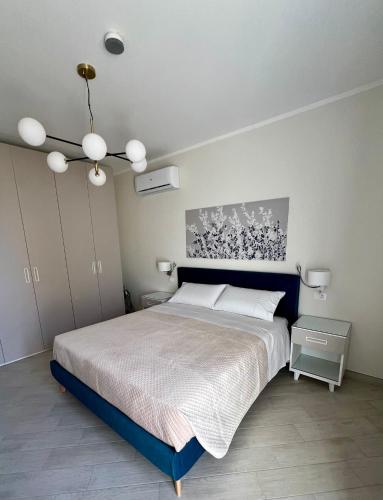 a bedroom with a large bed and a chandelier at NOVIMO Comfort Apartment with elevator and secure privat parking space in Terrasini