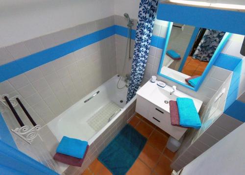 a bathroom with a tub and a sink and a mirror at Appartement Varangue, Anse des rochers in Saint-François