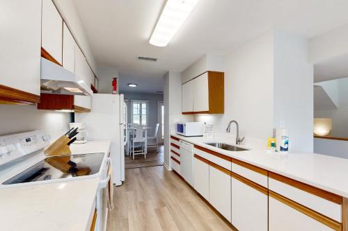 a kitchen with white cabinets and a sink at Barracuda #2B-CAC in Buxton