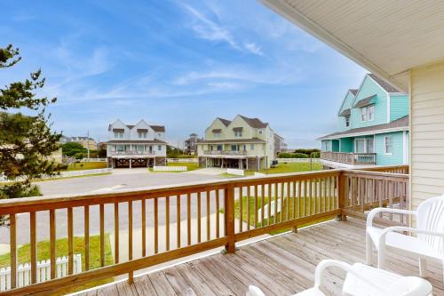 a large deck with white chairs and houses at Barracuda #2B-CAC in Buxton