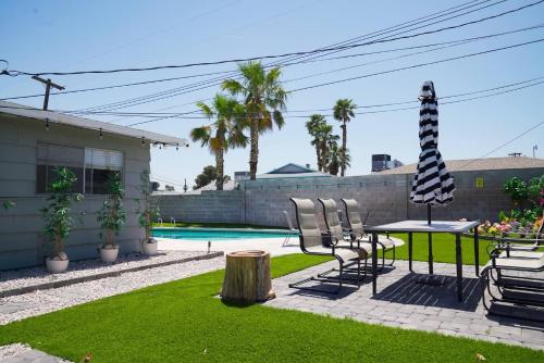 a backyard with chairs and a table and a pool at Vegas Hideaway with Jacuzzi & Pool by Strip in Las Vegas