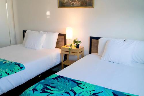 two beds sitting next to each other in a room at Vegas Hideaway with Jacuzzi & Pool by Strip in Las Vegas