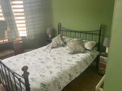 um quarto com uma cama com um edredão branco e almofadas em Seaside Villa on Secluded Green em Kent