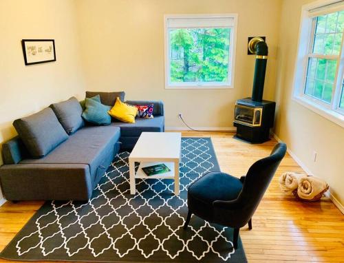 a living room with a couch and a stove at Blue Cedar Suite in Tofino