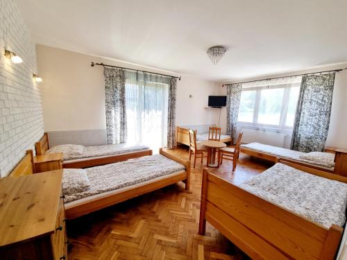 a room with four beds and a window at Hostel Rumiankowy Airport Hostel in Wrocław
