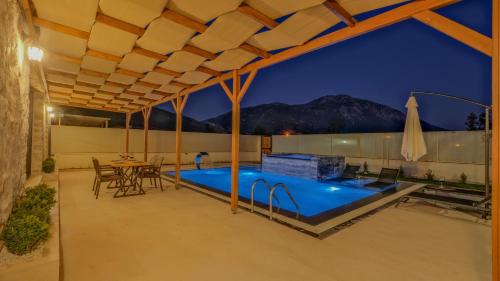a patio with a pool and a table and chairs at Oryap Villaları in Beyköyü