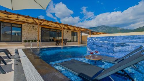 a villa with a pool with a chair and an umbrella at Oryap Villaları in Beyköyü