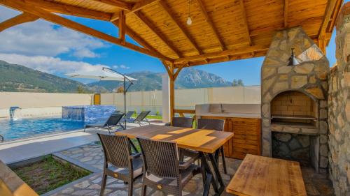 a patio with a table and a swimming pool at Oryap Villaları in Beyköyü