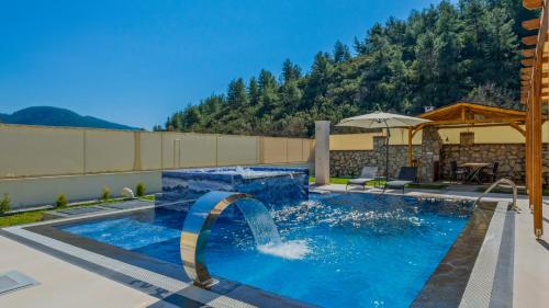 a swimming pool with a waterfall in the middle at Oryap Villaları in Beyköyü