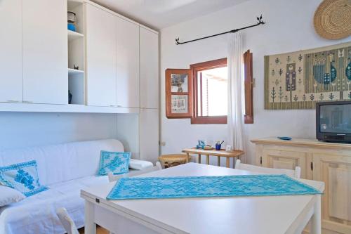 a living room with a white couch and a table at By the sea with amazing view in Capo Coda Cavallo