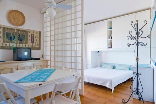 a bedroom with a bed and a table and chairs at By the sea with amazing view in Capo Coda Cavallo