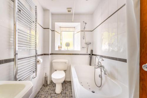uma casa de banho com um WC, uma banheira e um lavatório. em Grey Crag Barn em Grasmere