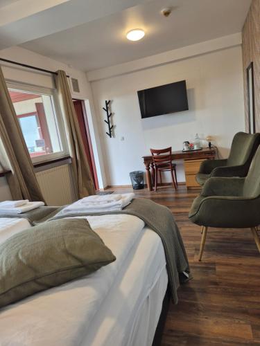 a hotel room with two beds and a chair at Hotel Hafnarfjall in Borgarnes