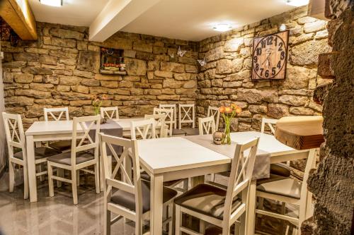restauracja ze stołami i krzesłami oraz kamienną ścianą w obiekcie Pokoje u Marioli w Wiśle