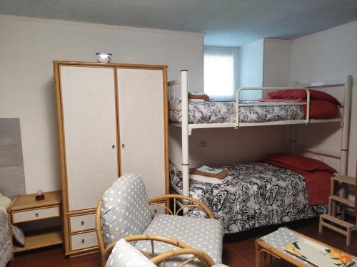Zimmer mit 2 Etagenbetten und einem Stuhl in der Unterkunft La Casina di Enea in Cascia