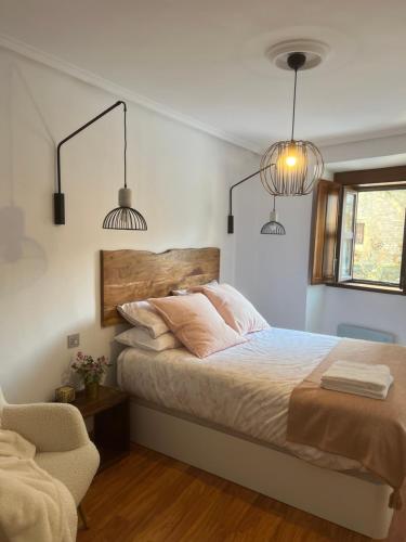 1 dormitorio con 1 cama con 2 lámparas y 1 silla en APARTAMENTO TURÍSTICO SAN NICOLAS, en Avilés