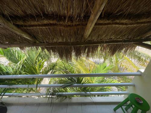 a straw roof with a chair and palm trees at Home's Jungle Puerto Morelos Cancun 20 Minutes from the Airport in Cancún