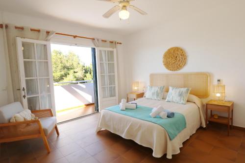1 dormitorio con 1 cama con toallas en Villa LAS MARINAS - 4, con piscina privada y a 5 minutos de la playa en Arenal d'en Castell