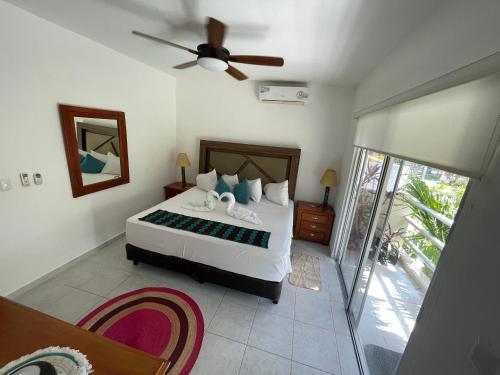 a bedroom with a bed and a ceiling fan at Home's Jungle Puerto Morelos Cancun 20 Minutes from the Airport in Cancún