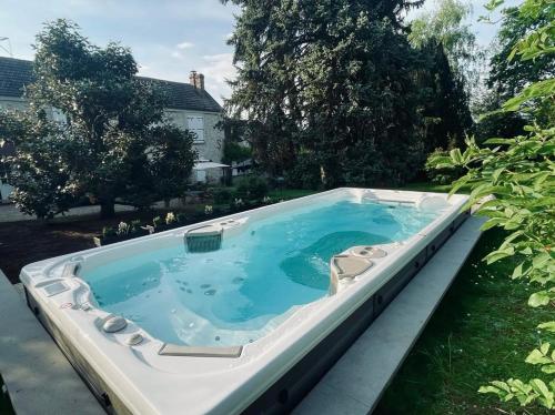 une baignoire jacuzzi dans l'arrière-cour d'une maison dans l'établissement GLYCINES COUNTRY GUESTHOUSE, à Goupillières