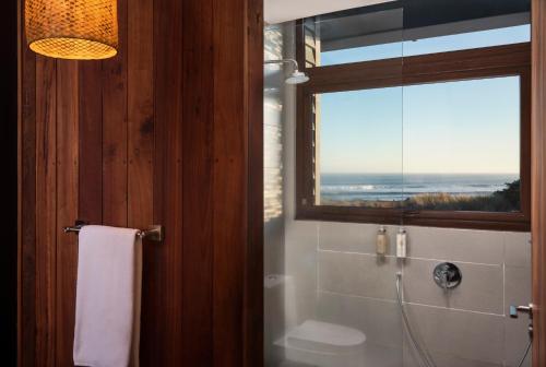 a bathroom with a shower and a window with a view at Hotel Alaia in Pichilemu