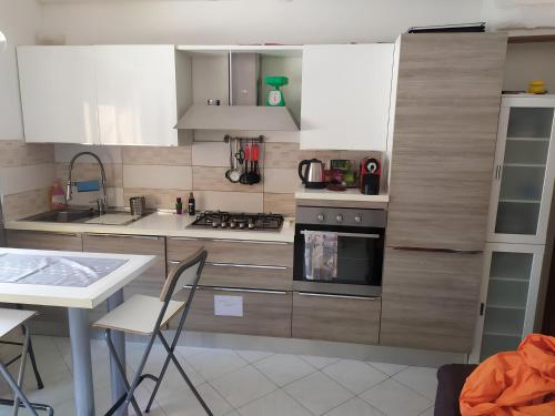 una cocina con electrodomésticos blancos, mesa y sillas en Cerroni's corner CISE 29636, en Roma