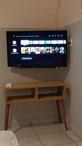 a flat screen tv sitting on top of a wooden stand at Garden House Katerina in Leptokaria