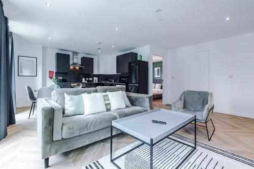 a living room with a couch and two chairs and a table at Luxury City Central Apartment. Roof Terrace, Gym, Cinema room + Games Area in Sheffield