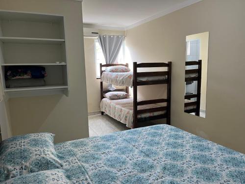 1 dormitorio con 2 literas y espejo en Residencial Recanto do Sossego en Bombinhas