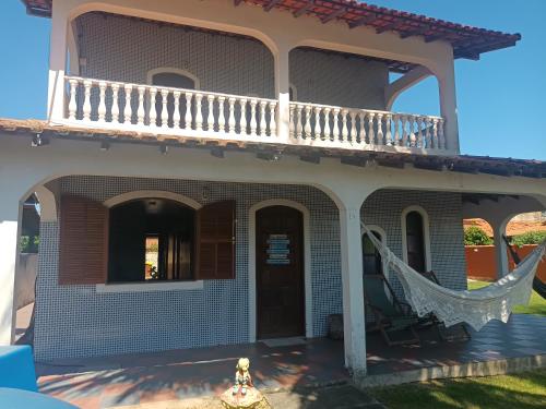 a house with a hammock on the porch at Casa em condomínio Praia Seca in Araruama