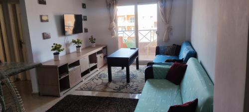 uma sala de estar com um sofá azul e uma secretária em شالية بأمكسيكو السخنة متميز em Ain Sokhna