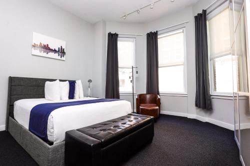 a hotel room with a bed and a chair at Large Stylish Newbury Street Studio w/ Kitchen in Boston