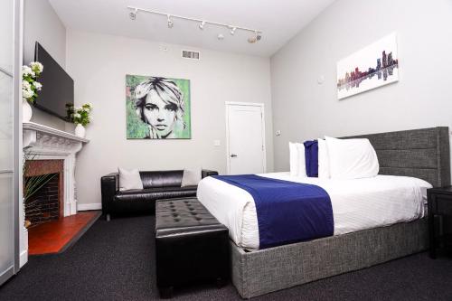 a bedroom with a bed and a living room with a fireplace at Large Stylish Newbury Street Studio w/ Kitchen in Boston
