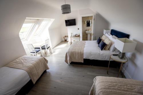 a bedroom with two beds and a table and chairs at Coastal View House in Doolin