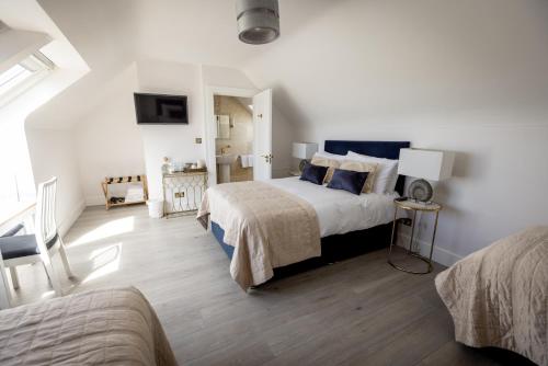 a bedroom with two beds and a television in it at Coastal View House in Doolin