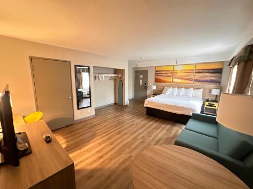 Habitación de hotel con cama y sofá en Days Inn & Suites by Wyndham Artesia en Artesia
