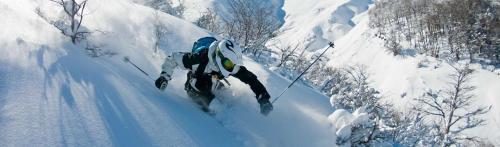 a man is skiing down a snow covered mountain at CABAÑAS LODGE LOS COIHUES 2 VALLE LAS TRANCAS/TERMAS DE CHILLAN /NEVADOS DE CHILLAN in Pinto