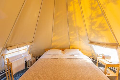 a small bedroom with a bed in a tent at SOL Glamping at Khao yai in Ban Nong Makha