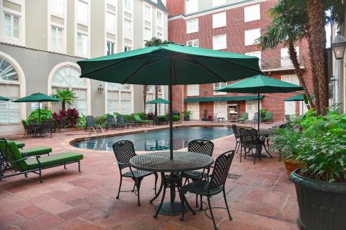 a table and chairs with an umbrella next to a pool at Bourbon Orleans Hotel in New Orleans
