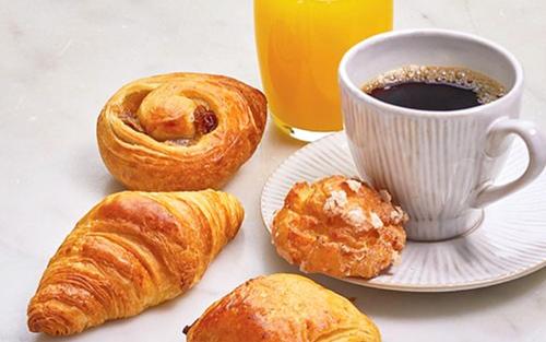 - une table avec une tasse de café et des croissants dans l'établissement Le Cygne Hotel & Restaurant, à Lauterbourg