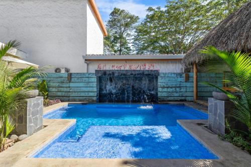 ポトレロにあるLuxury Retreat Villa private Pool & BBQ by SPCRの滝のある家の裏庭にあるプール