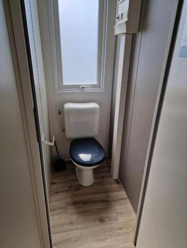 Elle comprend une petite salle de bains pourvue de toilettes et d'une fenêtre. dans l'établissement CAMPING VALRAS PLAGE 5 ETOILES, à Vendres